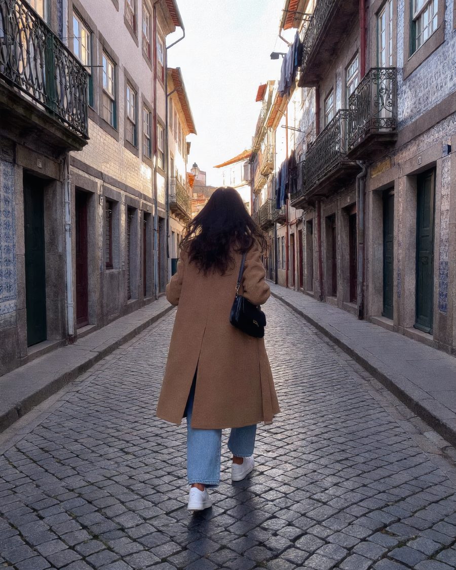 Lia walks away up a narrow cobbled street in Porto.